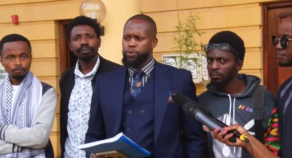 Photo of Nicholas Wambugu, Chris Wamae, Brian Adagala and Markdenver Kariuki with their Lawyer; Ian Mutiso (C) outside Milimani Law Courts